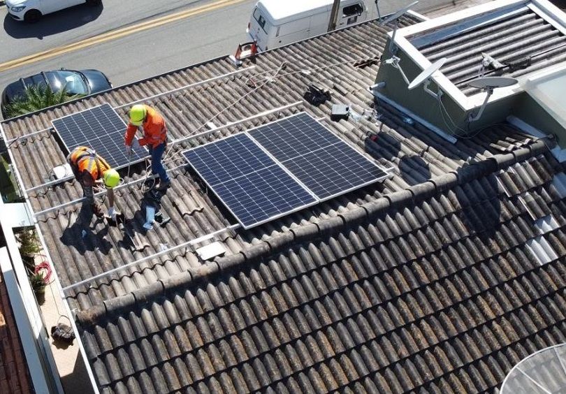 Equipe da Solar Jugaad montando placas solares em um telhado